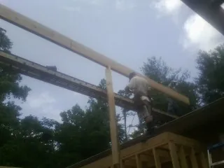 Carpenter setting a ridge beam over a new addition frame — Ice Dam Removal by Roofing Brothers in Corpus Christi