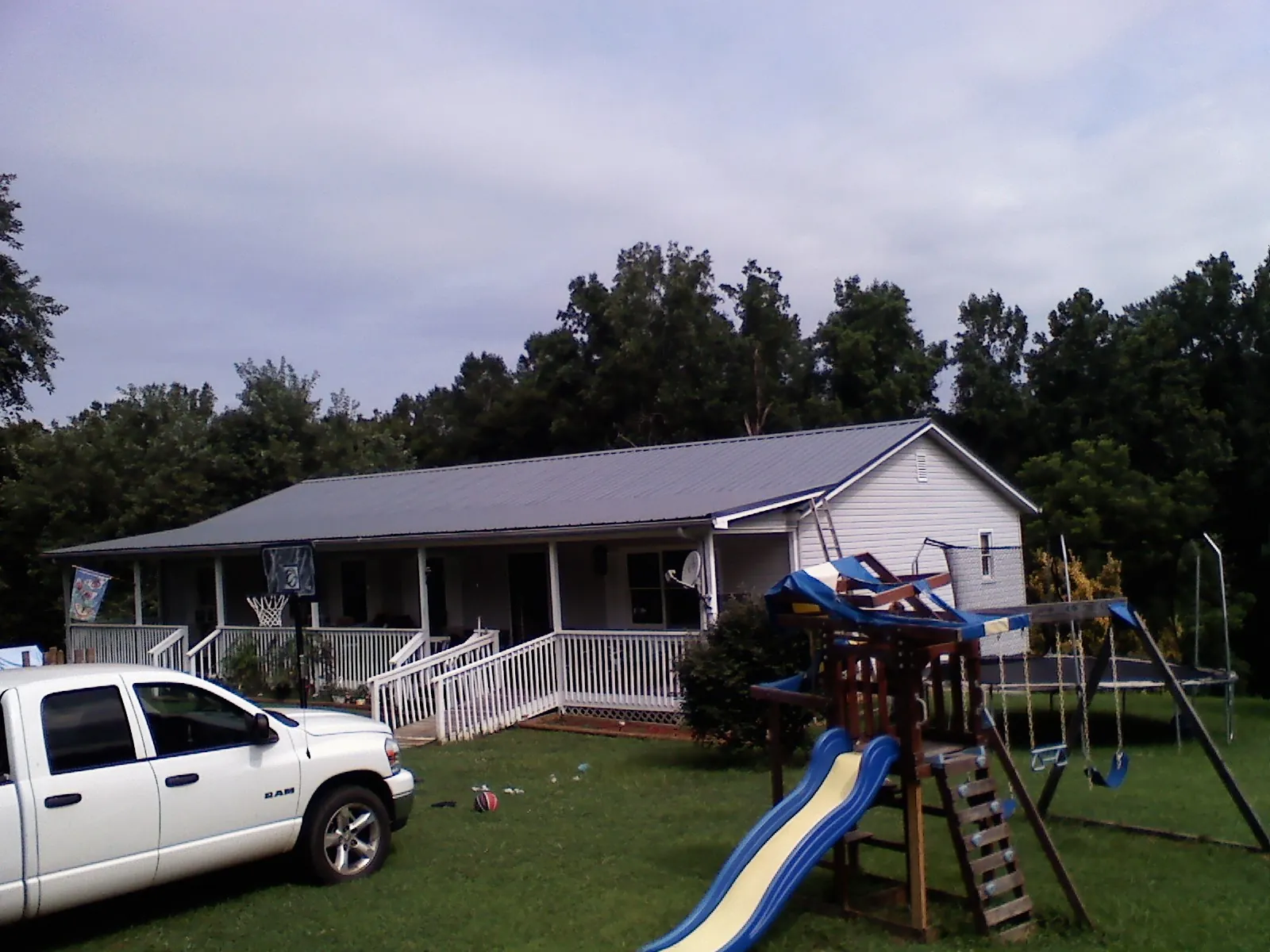 Dark metal roof on a country home with a full length front porch in Corpus Christi